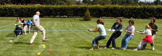 Four way tug of war with referee trying to get out of way